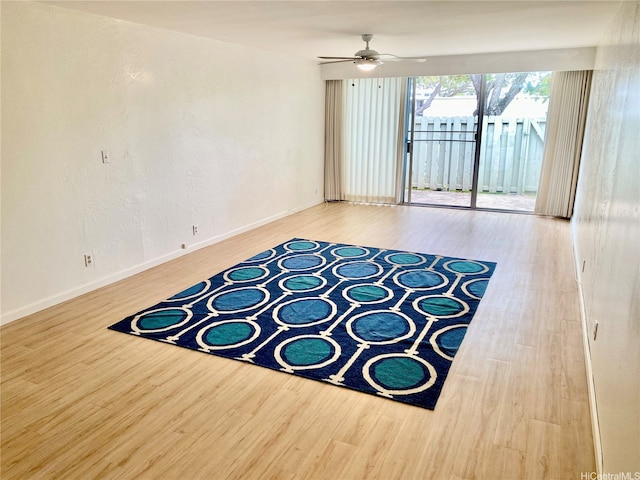 empty room featuring baseboards, ceiling fan, and wood finished floors