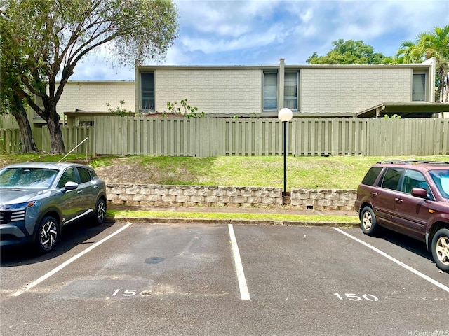 uncovered parking lot featuring fence