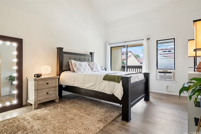 bedroom with wood finished floors, baseboards, high vaulted ceiling, access to outside, and cooling unit
