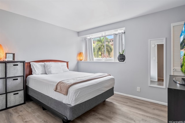 bedroom with baseboards and wood finished floors