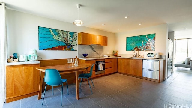 kitchen with light countertops, appliances with stainless steel finishes, and brown cabinetry
