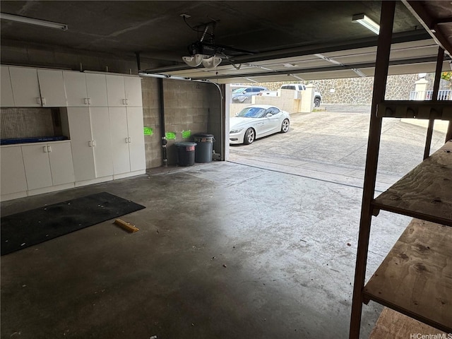 garage with concrete block wall and a garage door opener