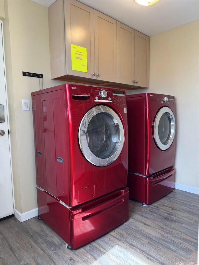 laundry area with baseboards, wood finished floors, independent washer and dryer, and cabinet space