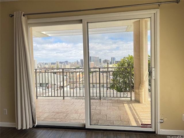 entryway featuring wood finished floors, baseboards, and a view of city