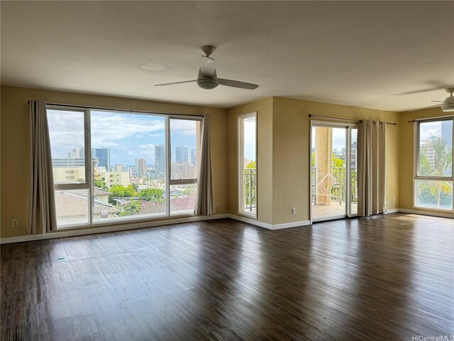 interior space featuring dark wood-type flooring, a ceiling fan, and baseboards