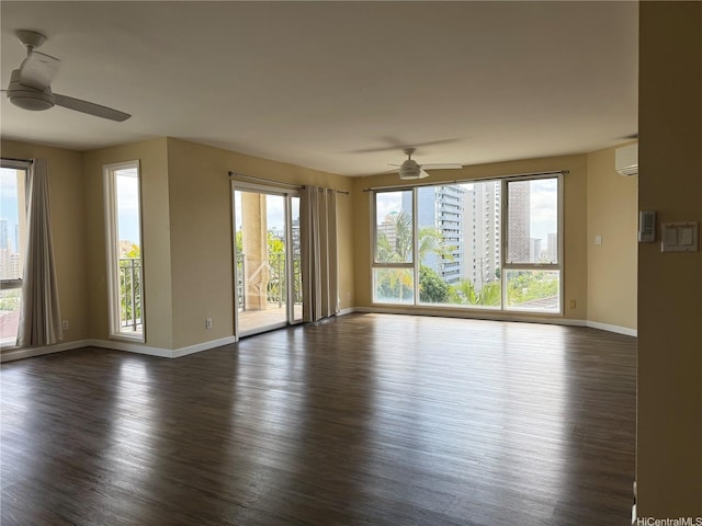 unfurnished living room with a ceiling fan, baseboards, dark wood-style flooring, and a wall unit AC