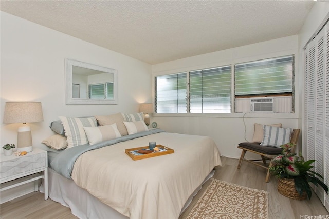 1334 Kuuna St, Kailua, HI 96734 - bedroom with wood finished floors, a closet, a textured ceiling, and cooling unit