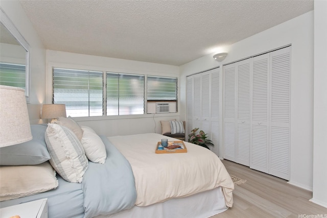 1334 Kuuna St, Kailua, HI 96734 - bedroom featuring wood finished floors, a textured ceiling, two closets, and cooling unit