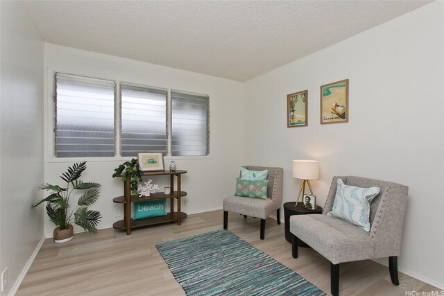 1334 Kuuna St, Kailua, HI 96734 - sitting room featuring light wood-style flooring, a textured ceiling, and baseboards