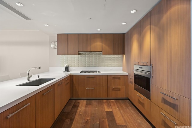 1555 Kapiolani Blvd Unit 1800, Honolulu, HI 96814 - kitchen with appliances with stainless steel finishes, a sink, dark wood-style flooring, light countertops, and decorative backsplash