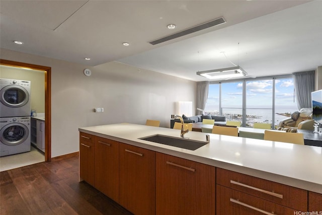 1555 Kapiolani Blvd Unit 1800, Honolulu, HI 96814 - kitchen with a sink, open floor plan, stacked washer and clothes dryer, dark wood-type flooring, and light countertops