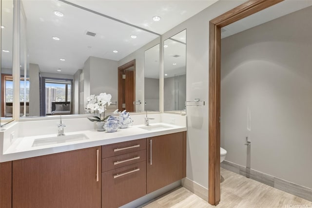 1555 Kapiolani Blvd Unit 1800, Honolulu, HI 96814 - full bathroom featuring toilet, wood finished floors, double vanity, recessed lighting, and baseboards