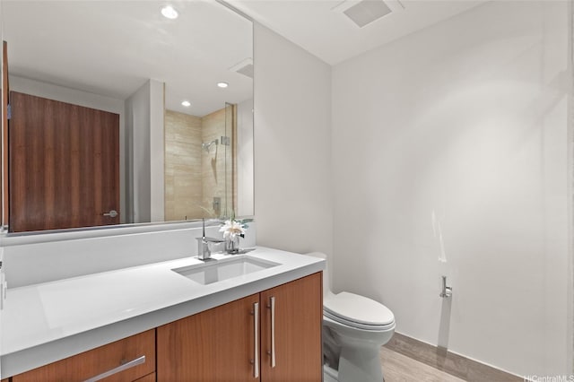 1555 Kapiolani Blvd Unit 1800, Honolulu, HI 96814 - bathroom featuring tiled shower, toilet, vanity, wood finished floors, and baseboards