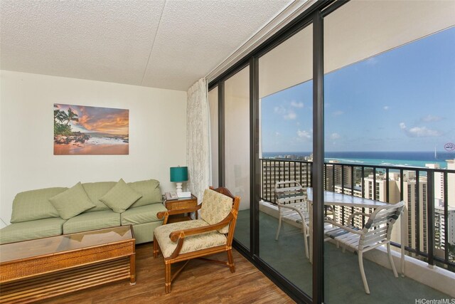 201 Ohua Ave Unit 3006, Honolulu, HI 96815 - living room with a water view, a textured ceiling, a wall of windows, and wood finished floors
