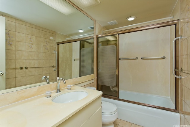 bathroom featuring visible vents, toilet, vanity, shower / bath combination with glass door, and tile patterned flooring