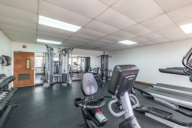 exercise room with a paneled ceiling and visible vents
