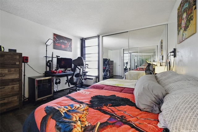 bedroom featuring wood finished floors, a textured ceiling, and a closet