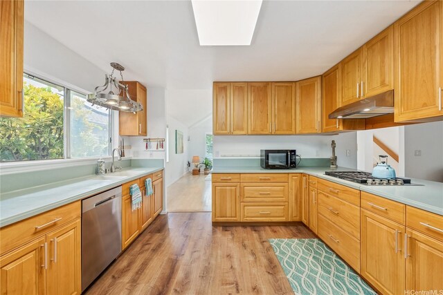 kitchen featuring a sink, light wood-style floors, light countertops, stainless steel appliances, and under cabinet range hood