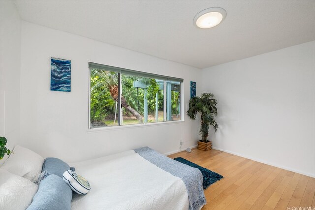 bedroom featuring light wood-style floors and baseboards