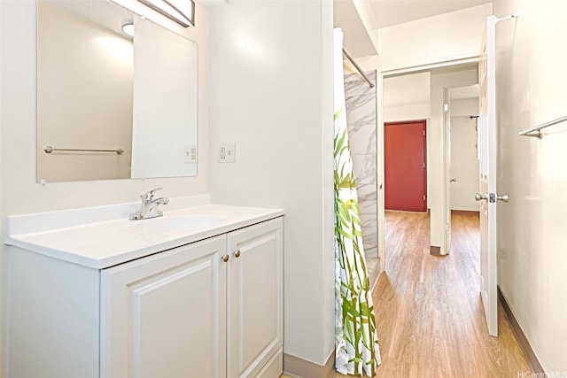 bathroom with a shower with shower curtain, vanity, and wood finished floors