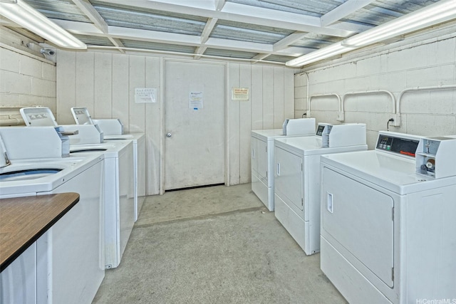 shared laundry area with washing machine and dryer and concrete block wall