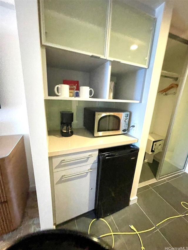 410 Atkinson Dr Unit 2213, Honolulu, HI 96814 - kitchen with white cabinetry, open shelves, black dishwasher, light countertops, and dark tile patterned floors