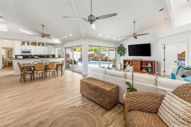 living area with light wood finished floors, recessed lighting, beamed ceiling, ceiling fan, and high vaulted ceiling