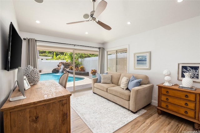 living room with light wood finished floors, a ceiling fan, and recessed lighting