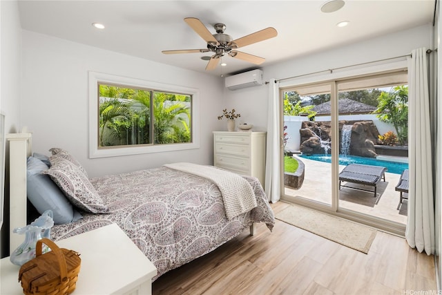 bedroom with a wall mounted AC, wood finished floors, access to exterior, and multiple windows