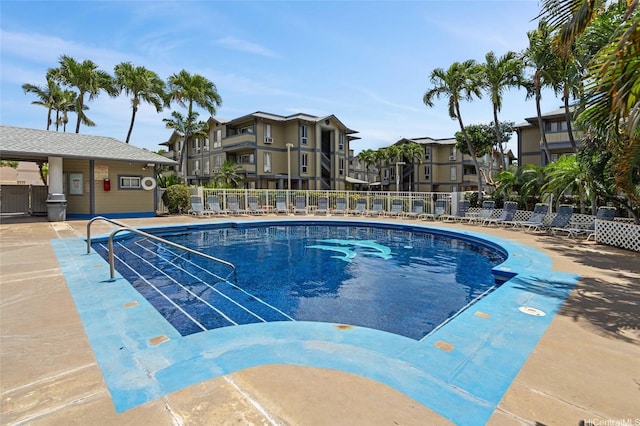 community pool with a patio and fence