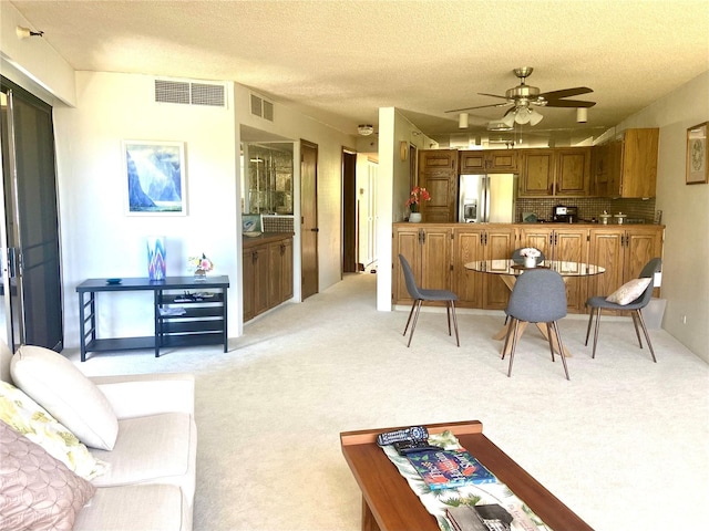 555 Hahaione St Unit 12D, Honolulu, HI 96825 - living room with light colored carpet, ceiling fan, a textured ceiling, and visible vents