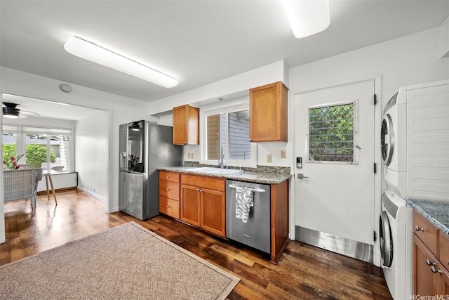 248 Aikane St, Kailua, HI 96734 - kitchen with appliances with stainless steel finishes, stacked washer / dryer, dark wood-type flooring, ceiling fan, and brown cabinetry