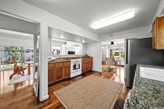 248 Aikane St, Kailua, HI 96734 - kitchen with white range with electric cooktop, brown cabinetry, dark wood finished floors, a ceiling fan, and freestanding refrigerator