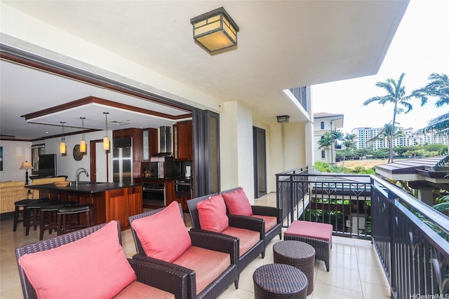 balcony featuring an outdoor living space, a bar, and a sink