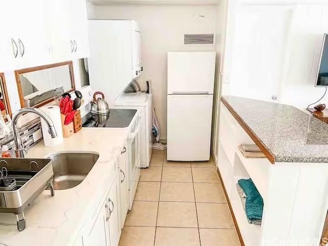 410 Nahua St Unit 212, Honolulu, HI 96815 - kitchen featuring a sink, light tile patterned floors, light countertops, white cabinets, and freestanding refrigerator