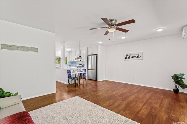 living room featuring ceiling fan, baseboards, and dark wood-type flooring