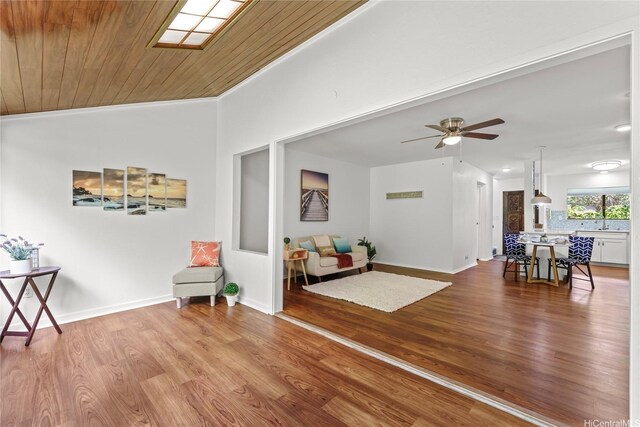 living area featuring a ceiling fan, wood finished floors, baseboards, wooden ceiling, and lofted ceiling