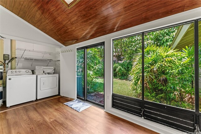 clothes washing area featuring washing machine and clothes dryer, wooden ceiling, wood finished floors, and laundry area