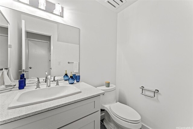 bathroom featuring visible vents, toilet, and vanity