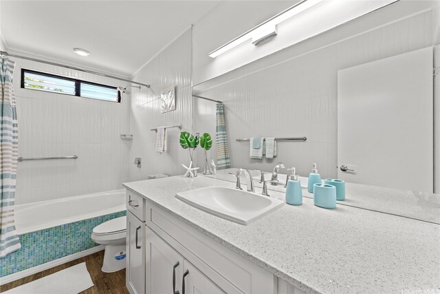 full bathroom with tiled shower / bath combo, toilet, vanity, and wood finished floors