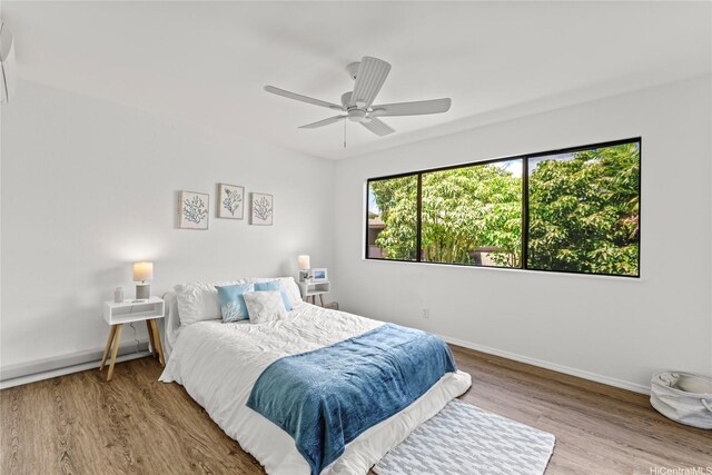 bedroom with wood finished floors, baseboards, and ceiling fan