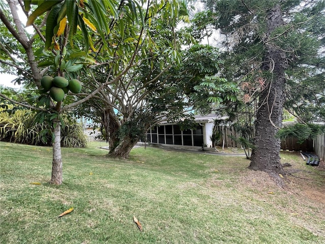view of yard featuring fence and a sunroom