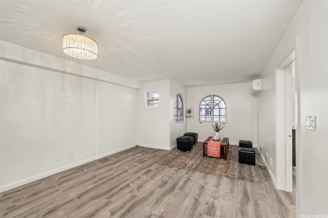 1433 Kewalo St Unit Ph12, Honolulu, HI 96822 - interior space featuring an AC wall unit, baseboards, a chandelier, and wood finished floors