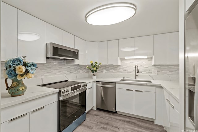 1433 Kewalo St Unit Ph12, Honolulu, HI 96822 - kitchen featuring a sink, decorative backsplash, white cabinetry, and stainless steel appliances