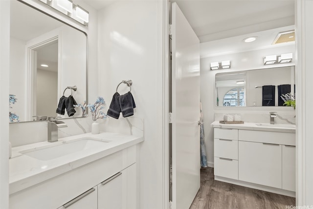 1433 Kewalo St Unit Ph12, Honolulu, HI 96822 - bathroom featuring a sink, visible vents, two vanities, and wood finished floors