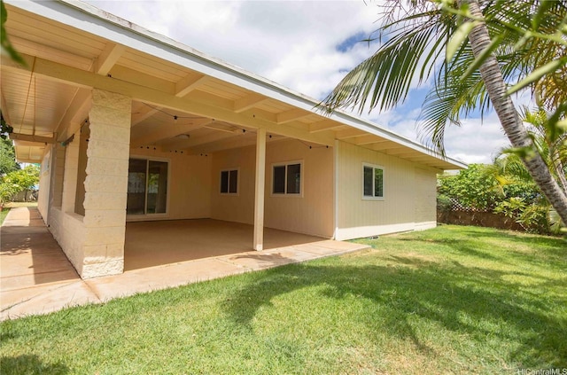 rear view of house featuring an attached carport, a yard, and a patio area