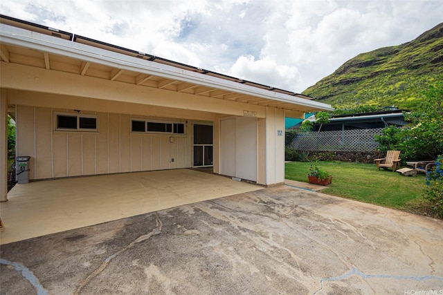 view of patio with a mountain view, a carport, aphalt driveway, and fence