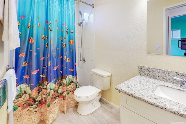 full bathroom featuring a shower with shower curtain, vanity, baseboards, toilet, and wood finished floors