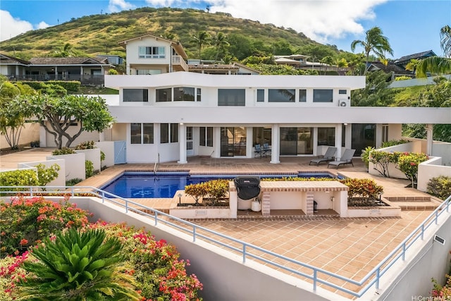 31 Poipu Dr, Honolulu, HI 96825 - back of house with a fenced in pool, fence, stucco siding, a patio area, and a mountain view