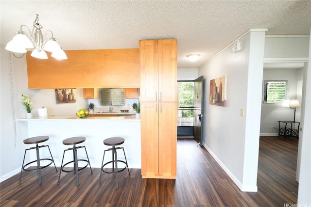 98-719 Iho Pl Unit 5/804, Aiea, HI 96701 - kitchen with dark wood finished floors, a breakfast bar, light countertops, a textured ceiling, and a chandelier